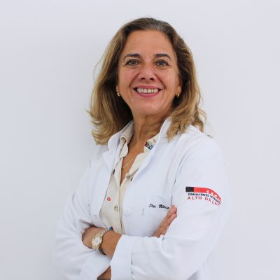 Médica veterinário de jaleco branco, com os braços cruzados, sorrindo para a câmera